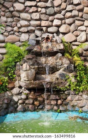 Decorative garden waterfall and pond made of stone 