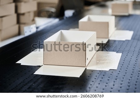 Decorative gift packaging production process showcases cardboard boxes on the conveyor in a modern factory setting