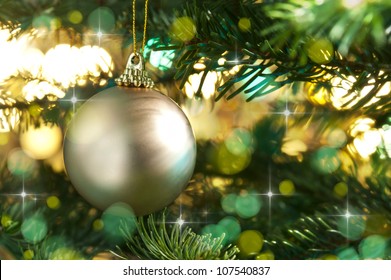 Decorative Gold Bauble In A Christmas Tree In Front Of A Glitter Background