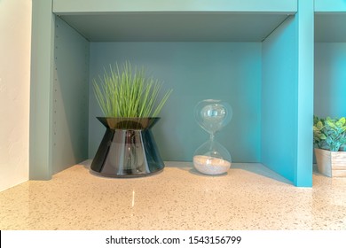 Decorative Grass Plant And Sand Timer On Bench