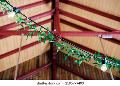 Decorative Green Garlands Made Of Plants. Wedding Decorations, Boho Style. Rustic Decor. Garlands From Plants With Lighting From Garden Lights. Greenery. 