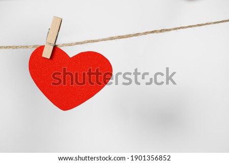 Decorative heart hanging on twine against white background, space for text. Valentine's Day