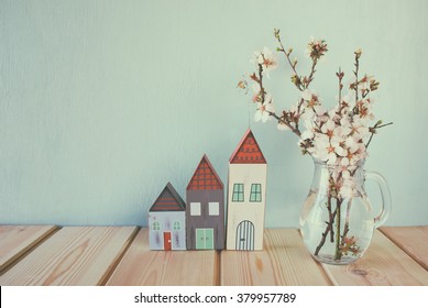 Decorative House Next To White Spring Flowers. Selective Focus. Vintage Filtered And Toned
