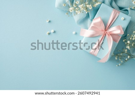 Decorative image featuring a delicate gift box adorned with pink ribbon and surrounded by flowers, set on a light blue backdrop to convey celebration, love, and thoughtful appreciation
