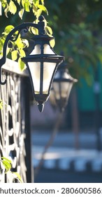 A decorative lantern casting warm light along a garden pathway during evening, creating a cozy and inviting outdoor ambiance.