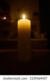 decorative large candle on the table in a dark room.