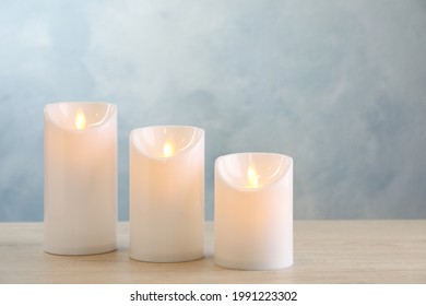 Decorative LED Candles On Light Wooden Table