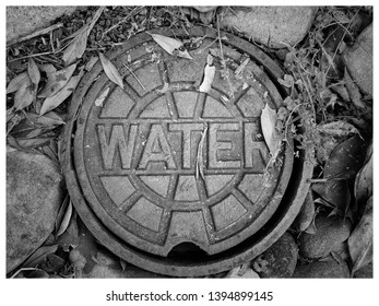 Decorative manhole water cover. Found in any city, any area of the country.  Black and white, monochrome image.