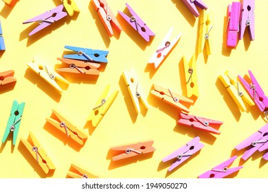 Decorative Multicolored Wooden Clothespins On A Yellow Background. Flat Lay Composition
