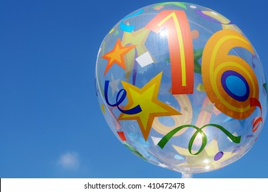 Decorative Mylar Balloon With The Number Sixteen On It. Blue Sky In The Background.