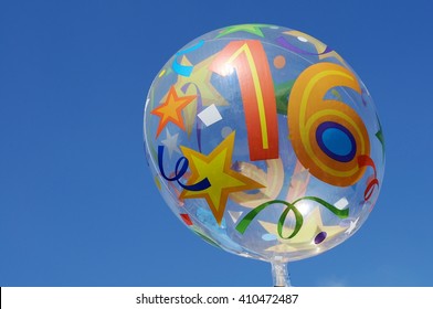 Decorative Mylar Balloon With The Number Sixteen On It. Clear Blue Sky In The Background.