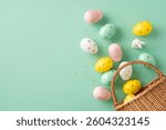 Decorative pastel Easter eggs with patterns are scattered around a basket on a green backdrop. This festive arrangement conveys the celebration of Easter and the joy of springtime.