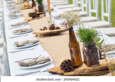 Decorative Plants In Vintage Bottles On Long Dining Table