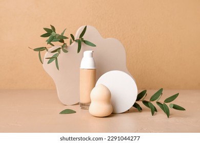 Decorative plaster podiums, bottle of makeup foundation and eucalyptus branches on beige background - Shutterstock ID 2291044277