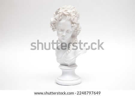 Decorative plaster statuette of a woman head on white background.