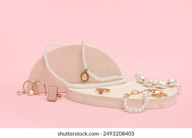 Decorative podium with jewelry on pink background. Closeup