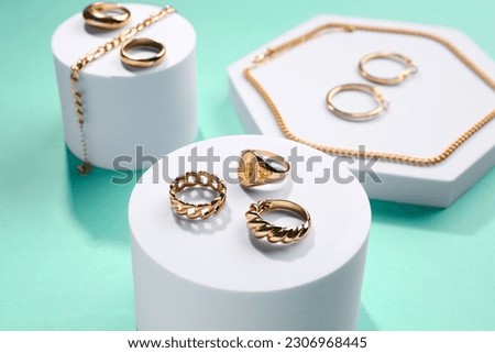 Decorative podiums with beautiful jewellery on turquoise background