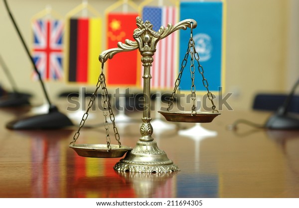 Decorative Scales of Justice with blurred National
flag of different countries, concept of International Law and
Order, focus on the
scales