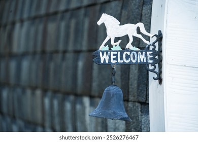 A decorative sign with a horse and bell, welcoming guests with a rustic charm. - Powered by Shutterstock