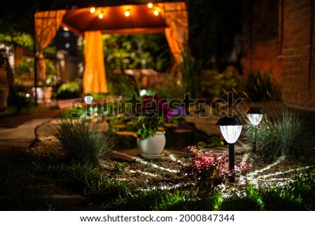 Decorative Small Solar Garden Light, Lanterns In Flower Bed. Garden Design. Solar Powered Lamp