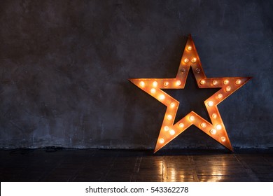 Decorative star with lamps on a background of wall. Modern grungy interior

