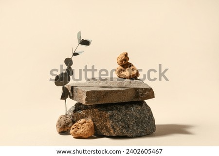 Decorative stone podiums with eucalyptus on beige background