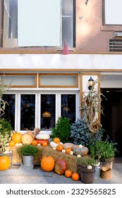 A decorative store front with pumpkins during the Halloween season.