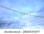 decorative string light hanging outdoors under a clear daylight sky