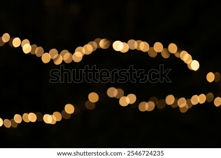 Decorative string lights at night time, Defocused Background, night city backdrop, party time with Yellow bokeh balls. Abstract blurred warm light