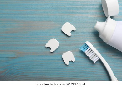 Decorative teeth, toothbrush and paste on turquoise wooden table, flat lay. Space for text