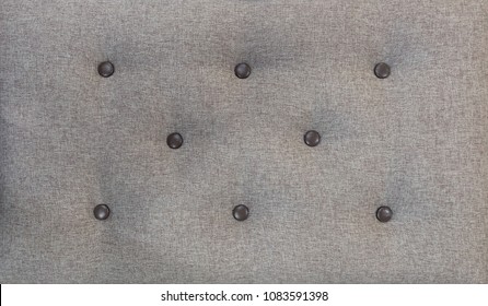 Decorative textile background with coach-type screed Capitone chesterfield texture. Beige chesterfield style quilted upholstery backdrop close up.