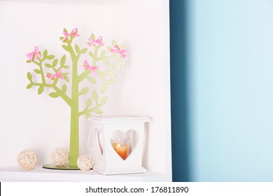 Decorative tree with  bows, on shelf, on blue wall background - Powered by Shutterstock