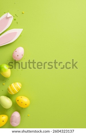 Decorative vertical Easter eggs with various patterns and bunny ears arranged on vibrant green background