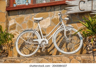 Decorative White Painted Old Bycicle On A Street