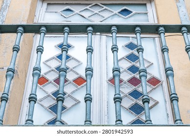 Decorative window with geometric glass pattern and metal bars in Porto Portugal