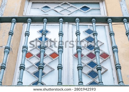 Decorative window with geometric glass pattern and metal bars in Porto Portugal