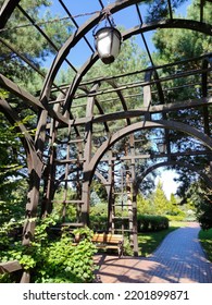 Decorative Wooden Arch Tunnel In The City Park. A Wooden Arch With Hanging Lanterns. Entrance To The City Park. Sights Of The City