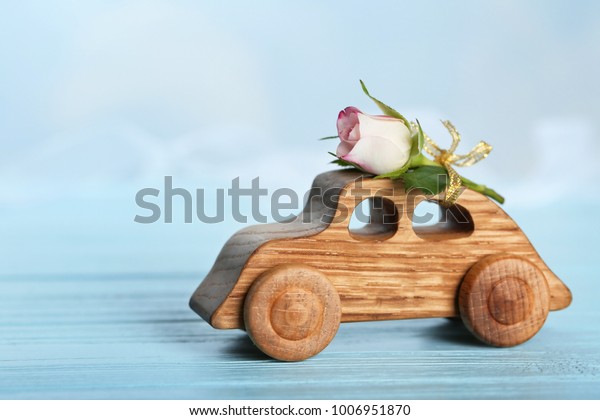 Decorative wooden
car with beautiful rose on
table