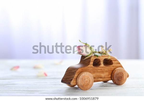 Decorative wooden\
car with beautiful rose on\
table
