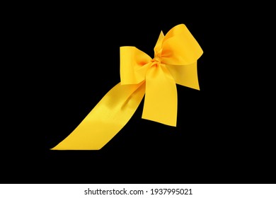 ruban et noeud jaune décoratif découpé et isolé sur fond noir
