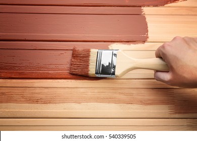 Decorator Painting Wood With Brown Paint