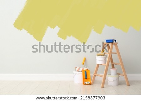 Decorator's kit of tools and paints near wall indoors