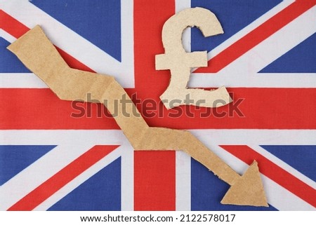 Decrease statistics concept. The flag of Great Britain has the pound symbol and an arrow pointing down.