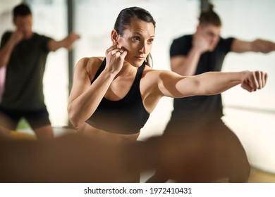 Dedicate sportswoman exercising a punch while having martial arts training at health club.  - Powered by Shutterstock