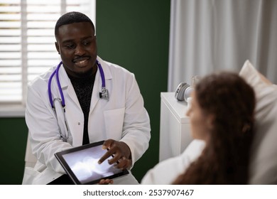 Dedicated African doctor explains leg X-ray results to a young patient, ensuring clear communication about her health journey. - Powered by Shutterstock