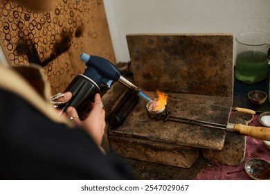 A dedicated artisan uses a torch to melt metal, creating exquisite jewelry designs. - Powered by Shutterstock