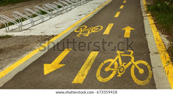 dedicated dedicated asphalt road for biking. A\
bicycle dedicated road in city street. Area for bicycling in city\
park. Painted sign, bike path\
marking