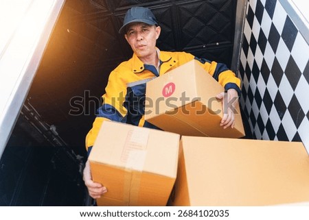A dedicated delivery worker is lifting boxes from a truck, showcasing his commitment to logistics and efficient service in a dynamic environment.