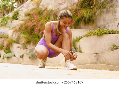 A dedicated fitness enthusiast can be seen tying their sneakers while enjoying the outdoors