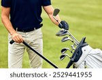 A dedicated golfer carefully adjusts his golf clubs while standing on the lush green fairway, fully prepared and focused, ready for an exciting and thrilling game ahead with friends